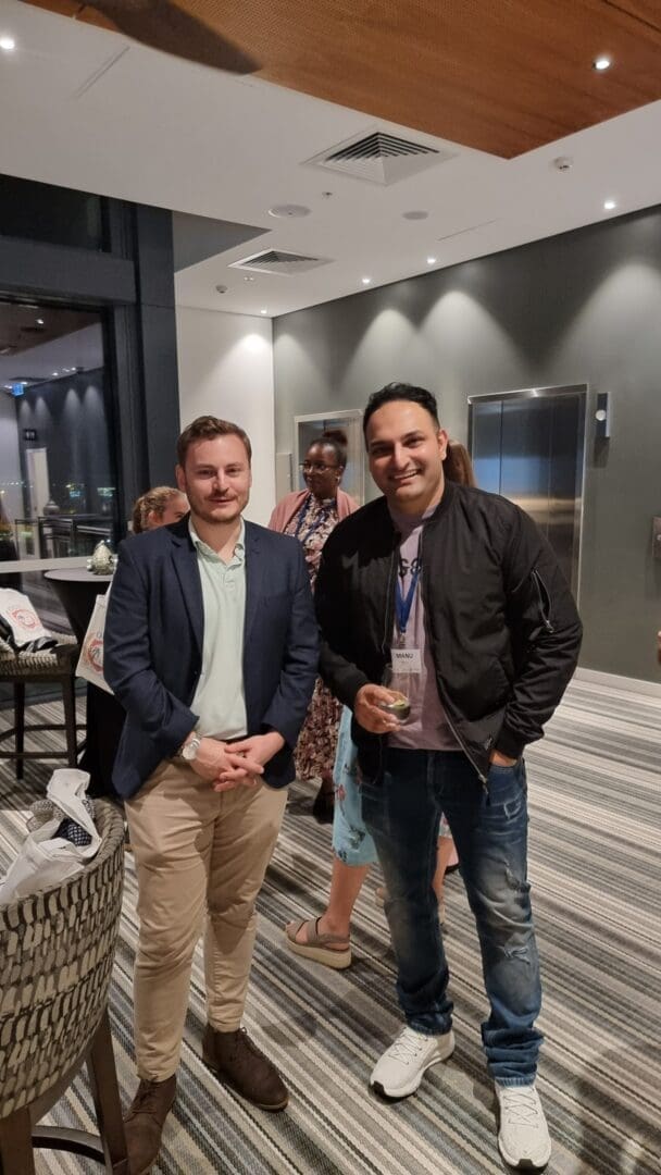 Young men cocktail reception casual dress one drink white sneakers smiling OUM