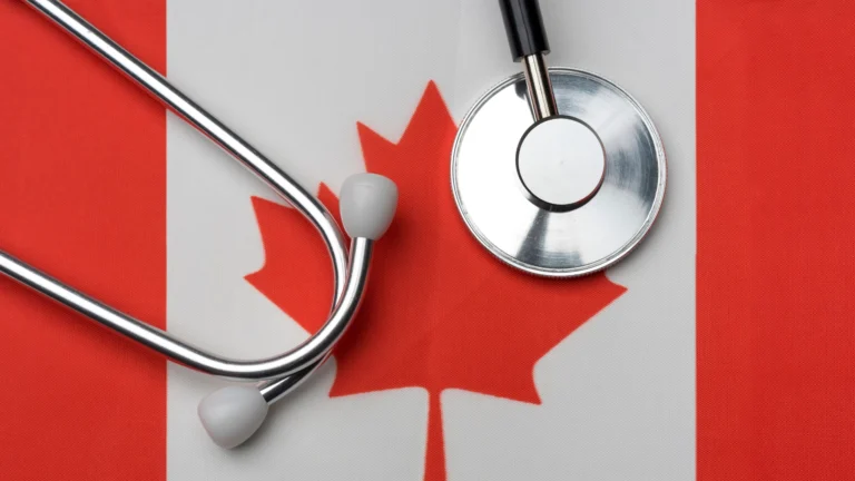A stethoscope placed on top of a Canadian flag, symbolizing healthcare and the medical profession in Canada