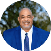 A headshot of a man in a suit and tie