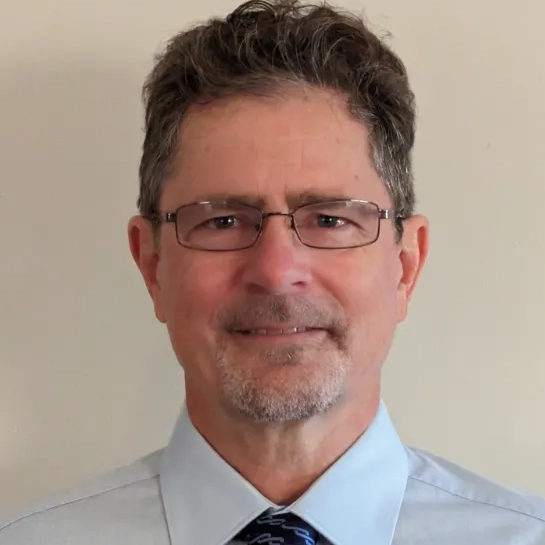 Man smiling wearing shirt and tie with glasses