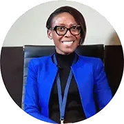A portrait of a smiling professional black woman wearing blue suit and black blouse sitting in a managers chair