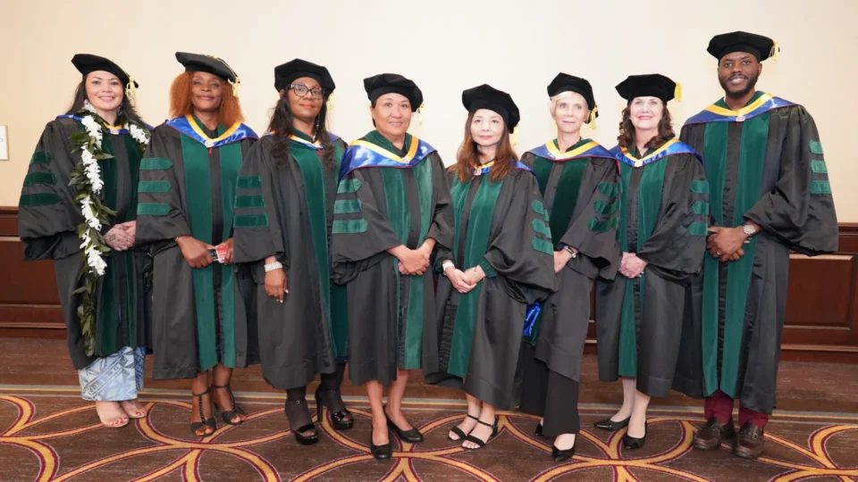 Medical school graduating students in black and green cap and gown