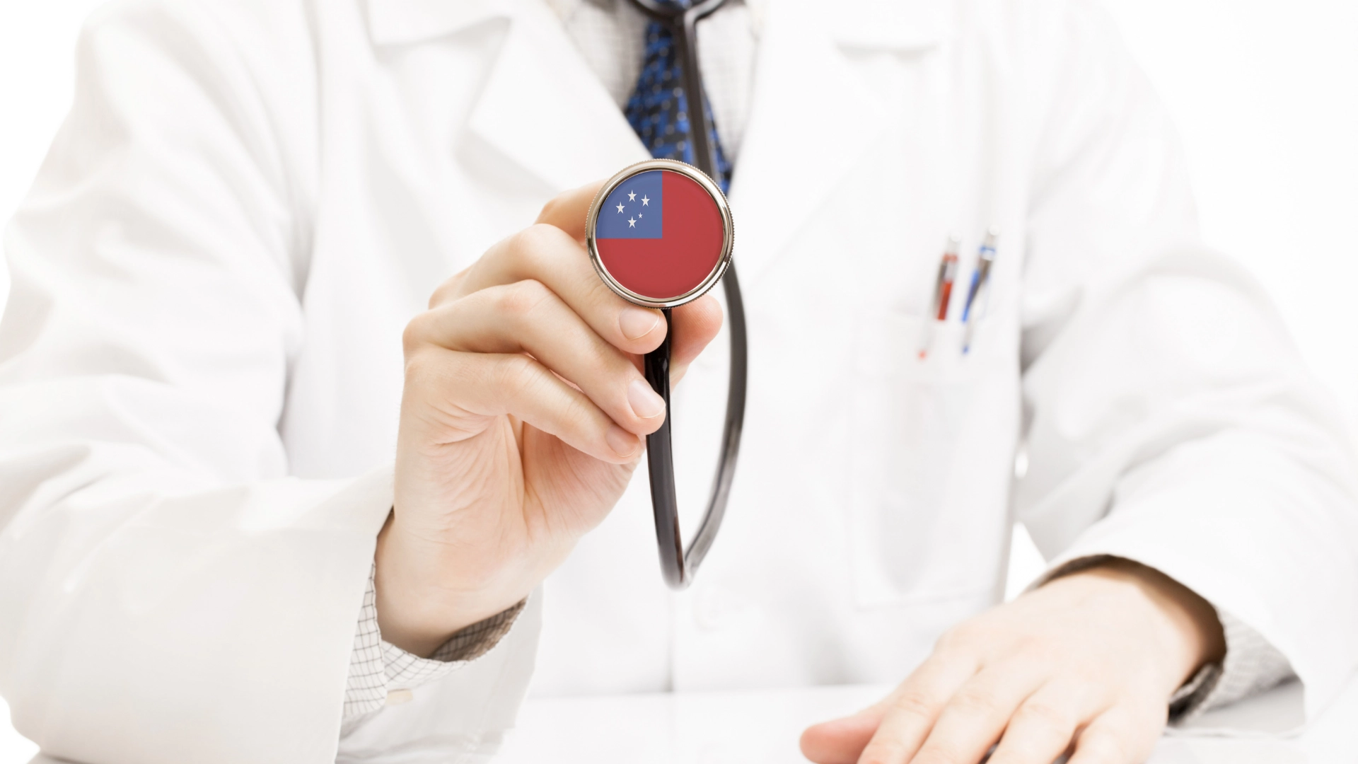 Doctor in a white coat holding a stethoscope with the flag of Samoa displayed on the chest piece, symbolizing healthcare and community service in Samoa