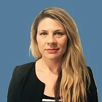 headshot of woman with long blong hair wearing a black blazer with a teal background